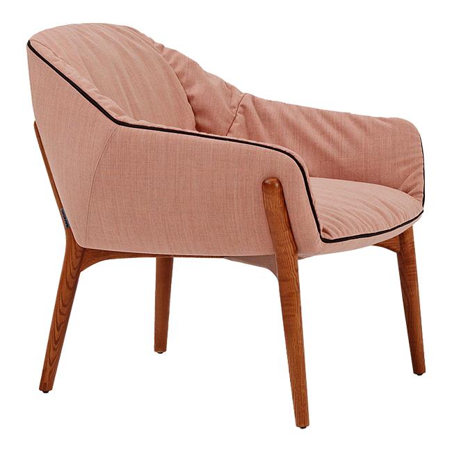 Blush pink upholstered chair with contrasting black piping and light wooden legs, featuring a minimalist design.