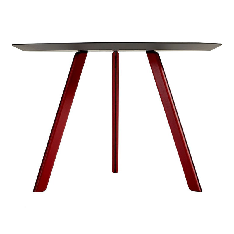 Red legs support a sleek black tabletop, showcasing a modern design with a minimalistic color contrast.