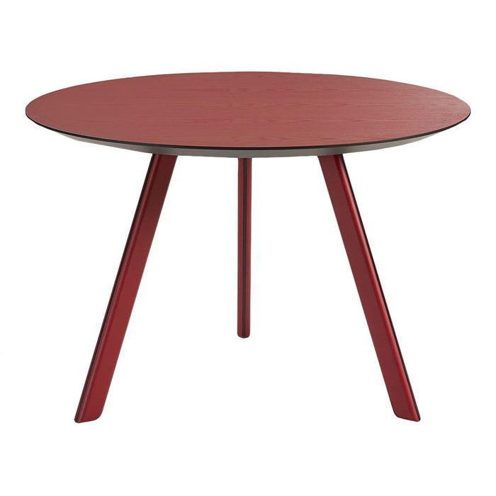 Round red dining table with sleek legs, featuring a smooth finish and minimalist design for modern decor.