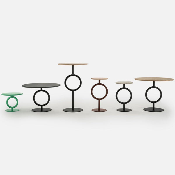 Colorful modern side tables featuring black, green, brown, and natural wood finishes with circular patterns.