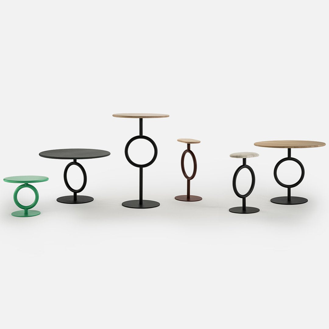 "Set of modern side tables in green, black, brown, and natural wood tones with circular patterns."
