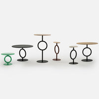 "Set of modern side tables in green, black, brown, and natural wood tones with circular patterns."