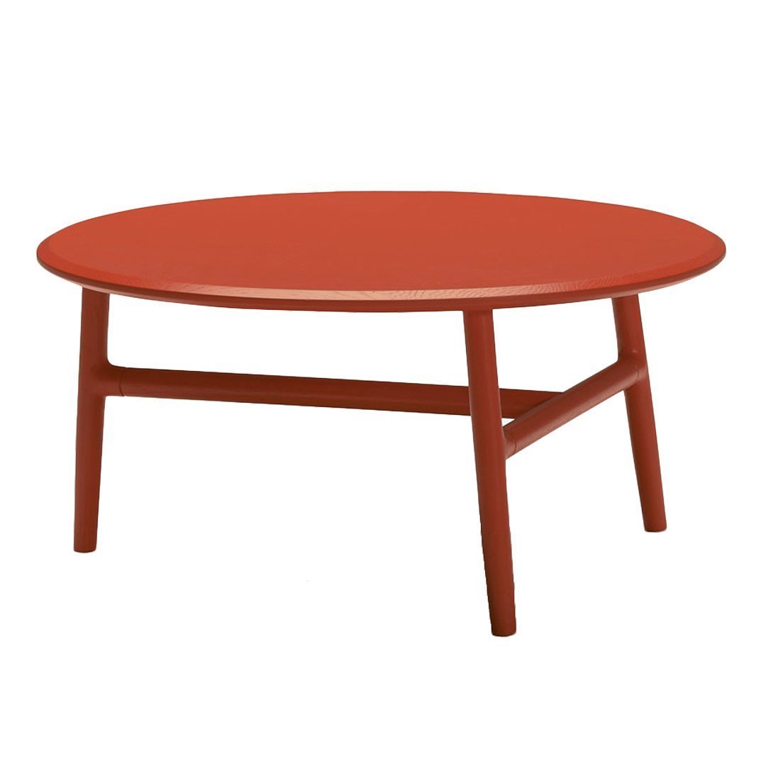 Round coffee table in rust orange with smooth finish and wooden legs, perfect for a modern living space.