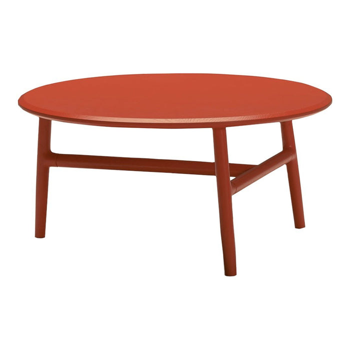 Round coffee table in a vibrant terracotta finish with minimalist design and smooth surface.
