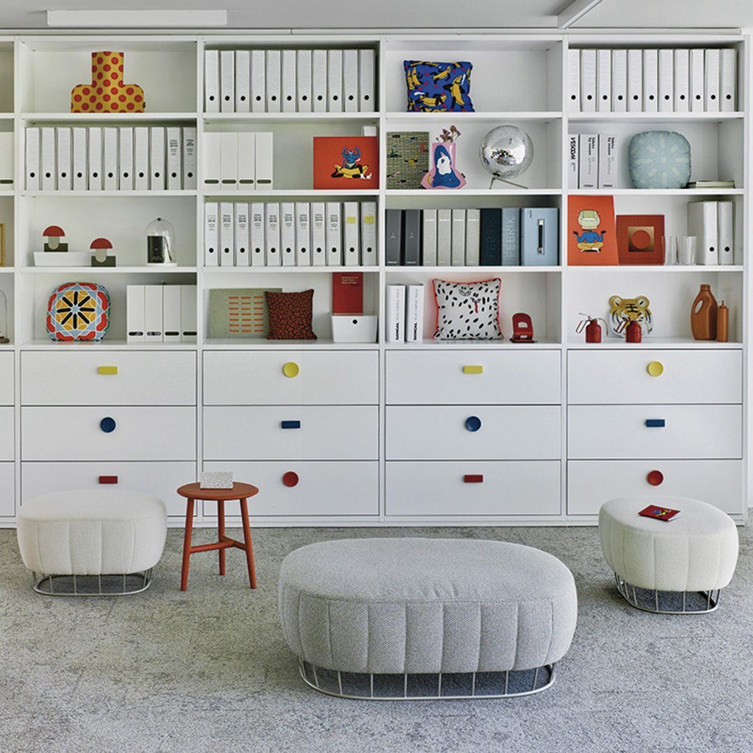 "Modern storage unit with colorful drawer knobs, featuring white shelves and playful decor in red, blue, and yellow patterns."