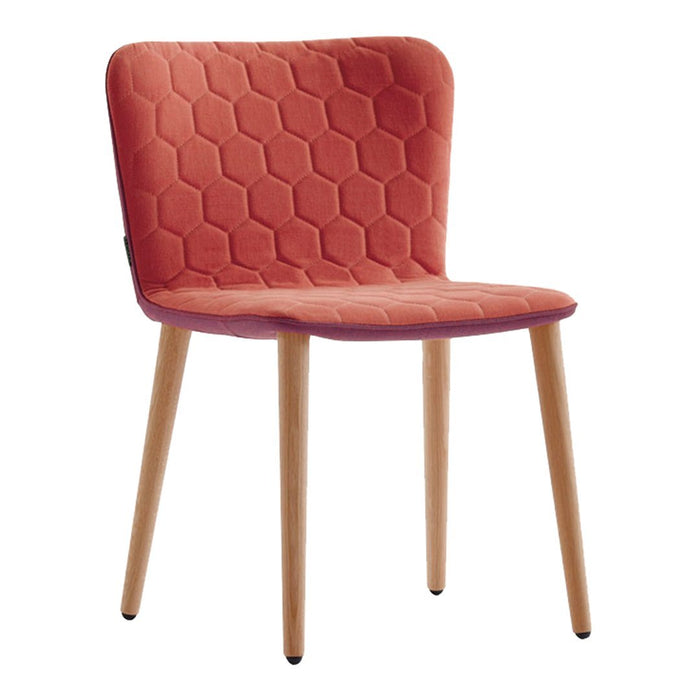 "Hexagon-patterned upholstery in coral, paired with natural wood legs, creating a modern dining chair design."