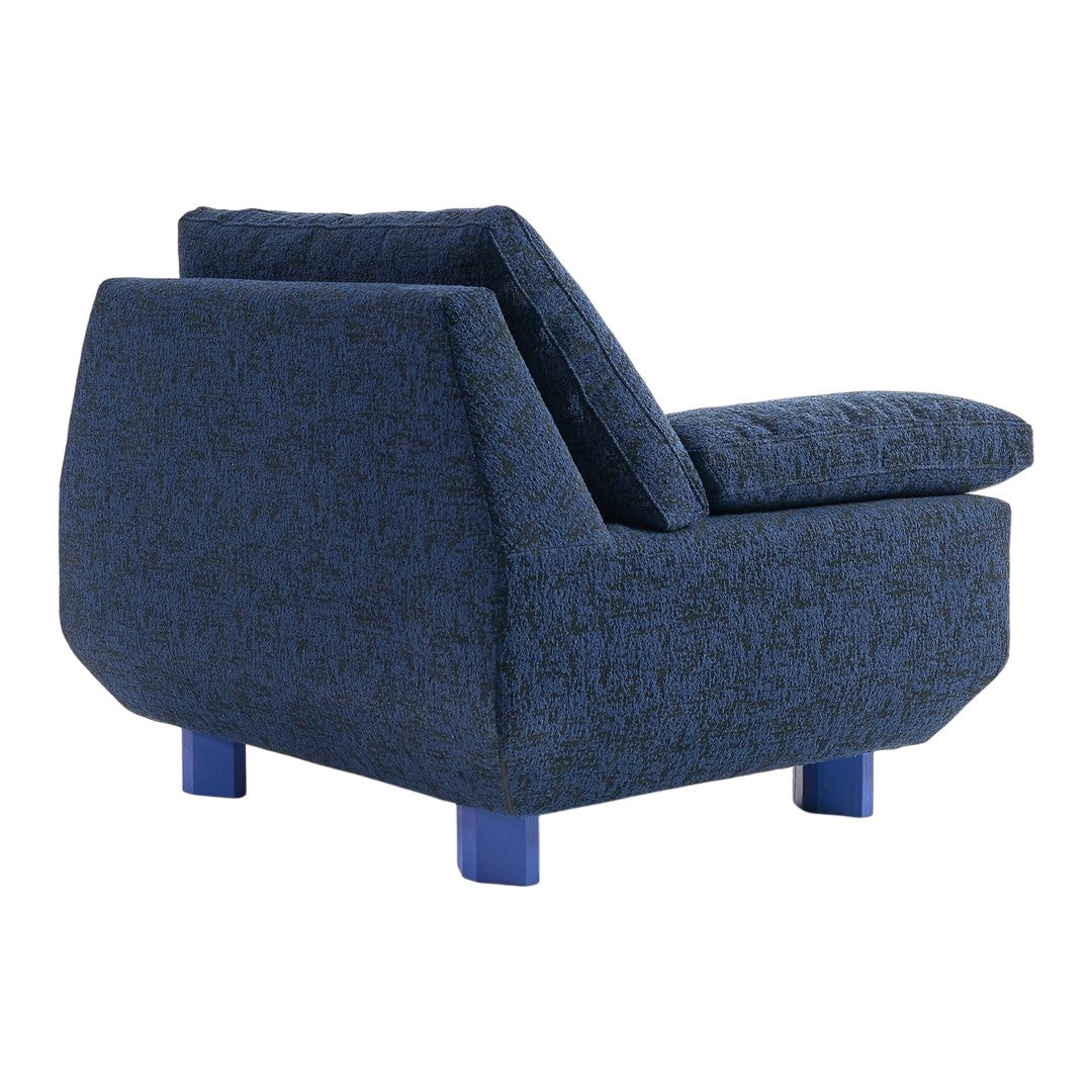 Blue patterned fabric armchair with bold blue legs and textured upholstery for modern decor.