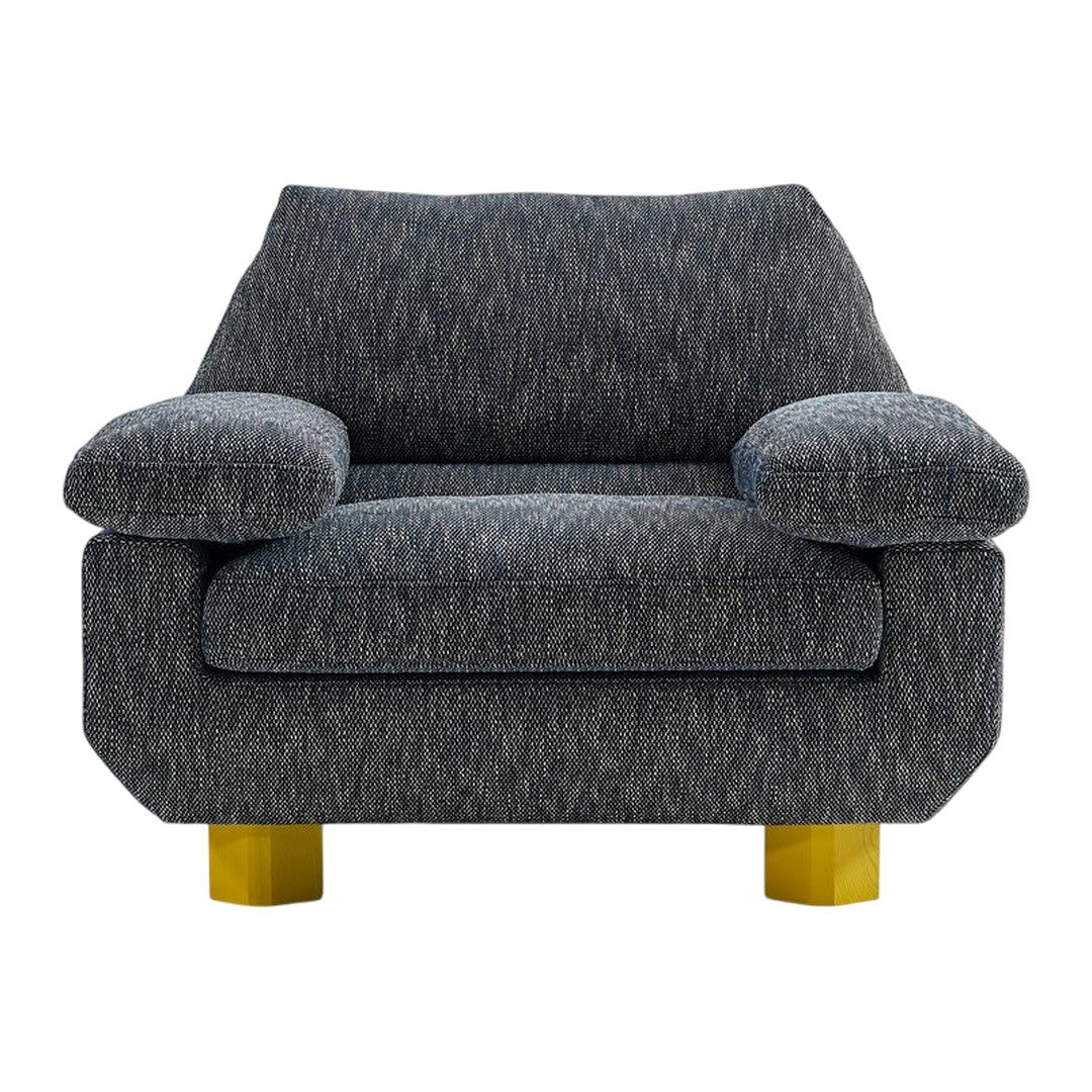 Gray textured fabric armchair with yellow geometric legs, ideal for modern decor.