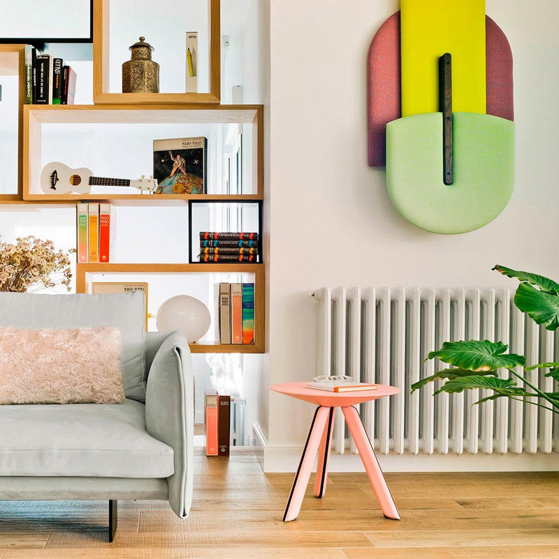 Modern living room featuring pastel green, purple, and pink colors with geometric patterns and natural wood accents.
