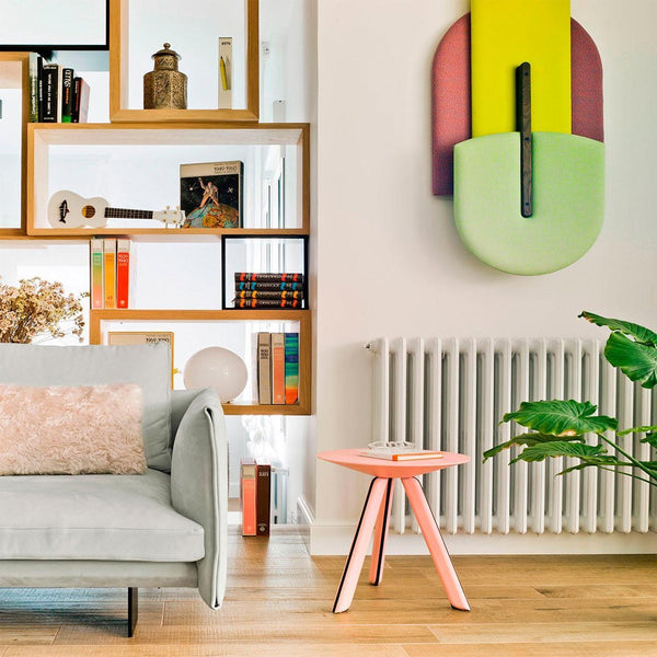 Pastel green and pink decor, with colorful geometric wall art, brightens a modern living room setting.