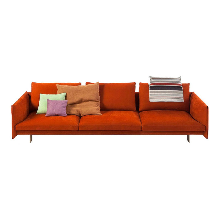 Vibrant orange sofa with multicolored patterned and solid cushions in green, brown, and striped designs.