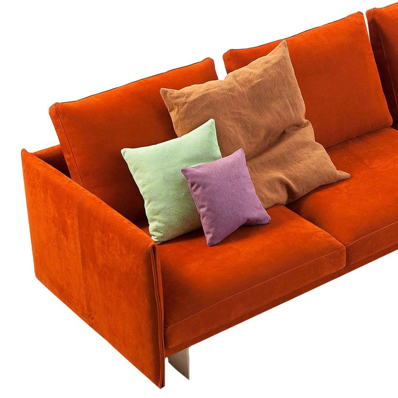 Vibrant orange sofa with textured cushions in mint green, brown, light purple, and deep purple hues.