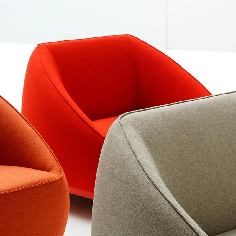 "Vibrant red and neutral gray cozy armchairs with smooth, modern shapes."