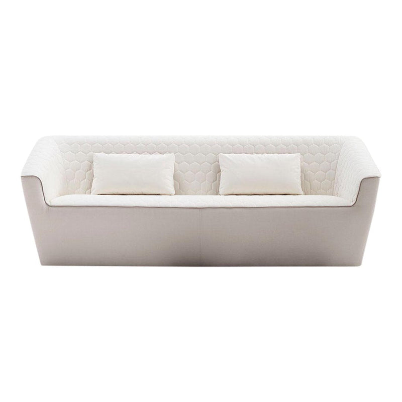 Modern white sofa with subtle quilted pattern and two matching cushions. Elegant and versatile for various decor styles.