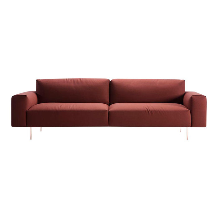 Rust-colored modern sofa with clean lines and smooth fabric, featuring minimalistic design and sleek metal legs.