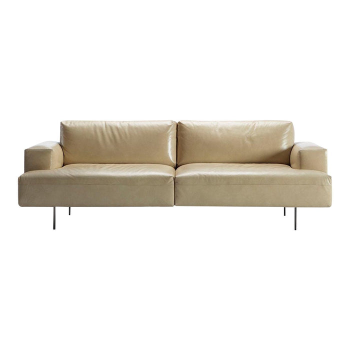 Beige leather sofa with a smooth, sleek surface and minimalistic design. Ideal for modern living spaces.