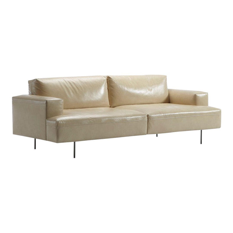 Beige leather sofa with smooth, sleek upholstery and minimalist design, featuring clean lines and chrome legs.