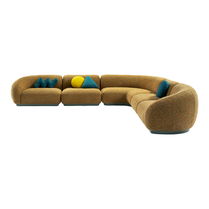 Curved sofa in warm brown fabric with teal and yellow accent pillows featuring geometric shapes. Ideal for modern decor.