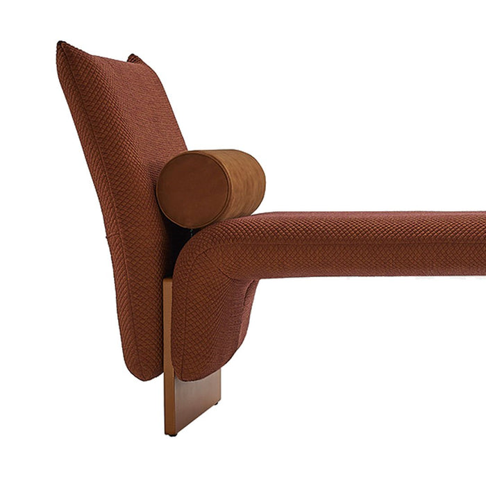 Rust-colored patterned chaise lounge with textured fabric and sleek wooden base.