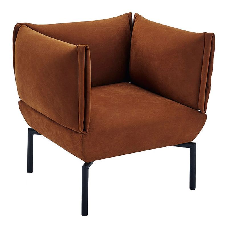 Rust orange velvet armchair with geometric silhouette and soft, cozy cushions, supported by sturdy black legs.