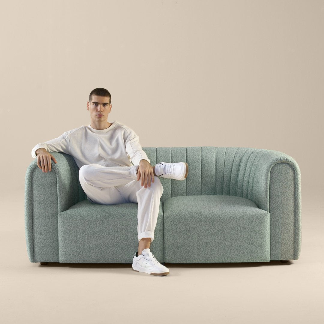 Stylish light blue couch with subtle ribbed pattern, perfect for modern interiors.