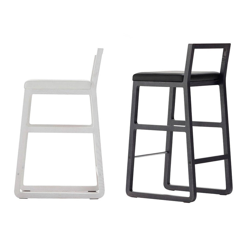 "Two modern bar stools in sleek white and black finishes, featuring minimalist design and clean lines."