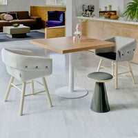 Modern dining set featuring gray and white chairs with wooden accents, a light wood table, and a green stool.