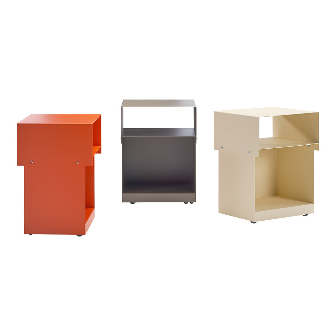 Colorful set of three modern side tables: bright orange, sleek gray, and soft beige with minimalist patterns.