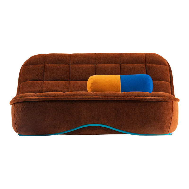Brown tufted sofa with a blue and orange cylindrical pillow, featuring a smooth texture and curved design.