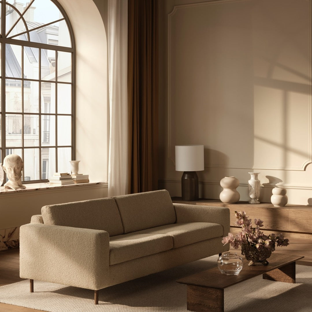 Beige sofa with clean lines, paired with warm wood tones and soft, neutral decor accents. Elegant, minimalist design.