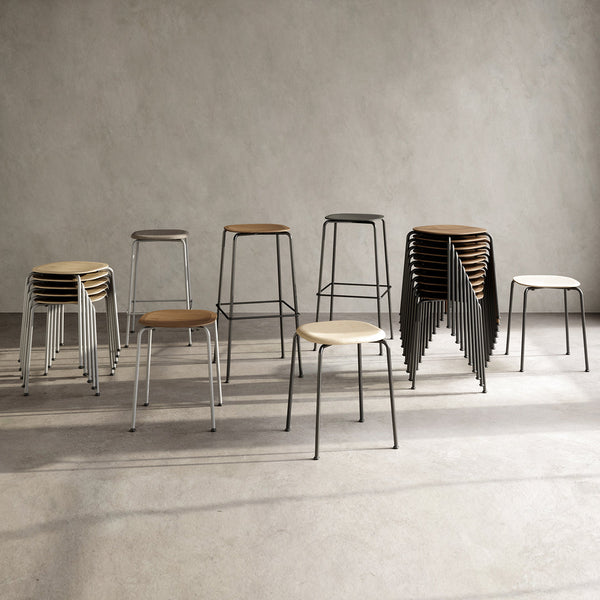 Stackable stools in wood and black metal, featuring a minimalist design with a mix of light and dark tones.