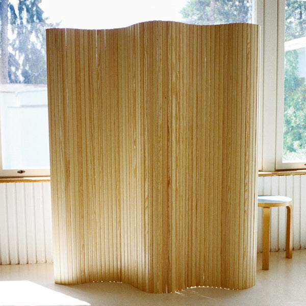 Natural wood room divider with a warm, honey-toned finish and wavy, vertical slats pattern. Perfect for modern decor.