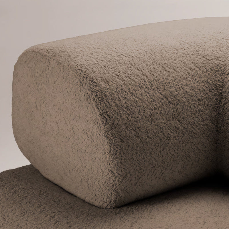 Textured beige cushion with a soft, velvety surface, highlighting subtle variations in color and pattern.