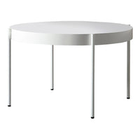 Round white table with sleek flat surface and minimalist design, featuring straight white legs.