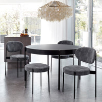 "Modern round black dining table with four gray upholstered chairs, featuring a sleek and minimalistic design."