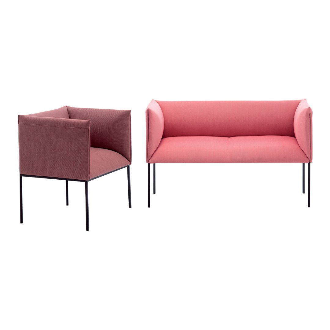 "Contemporary pink upholstered sofa and armchair with sleek black legs, featuring a smooth, minimalist design."