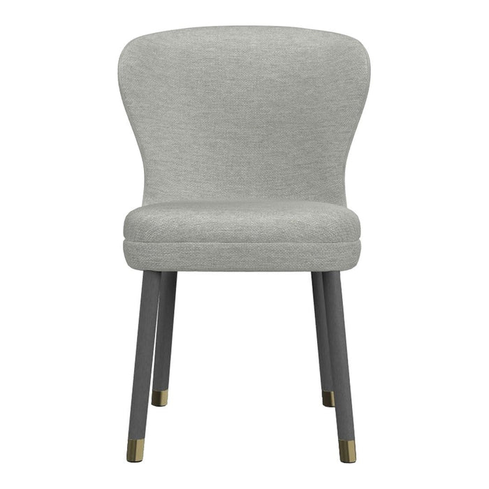 Light grey upholstered chair with a smooth, modern design and dark wooden legs featuring brass accents.