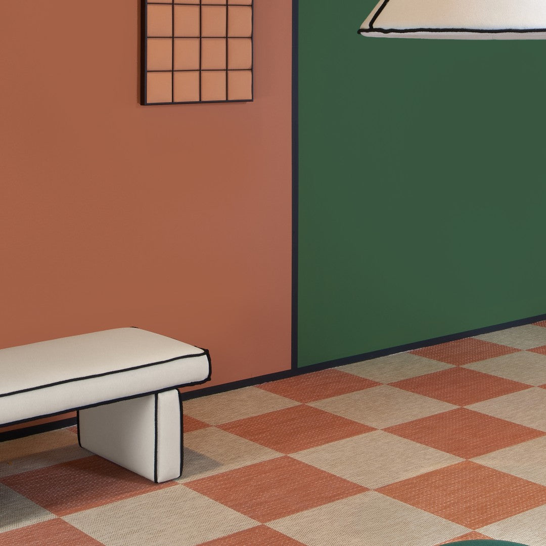 Colorful green and terracotta walls with checkerboard floor in shades of cream and burnt orange, creating a vibrant interior.