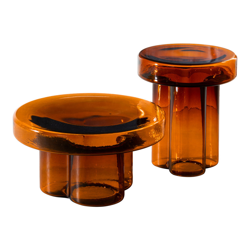 Amber glass accent tables with smooth, rounded shapes and a rich, warm color pattern.