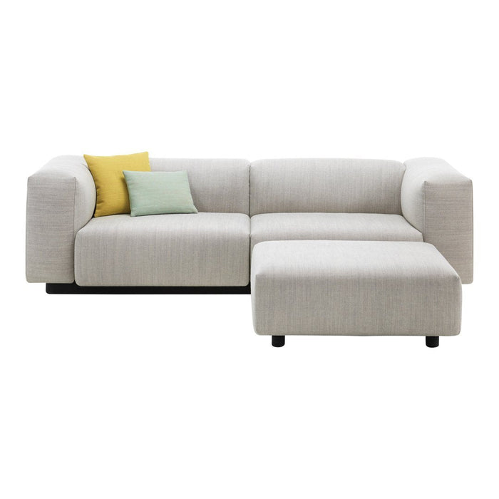 Light grey sectional sofa with yellow and mint accent pillows, featuring a clean, modern fabric texture.