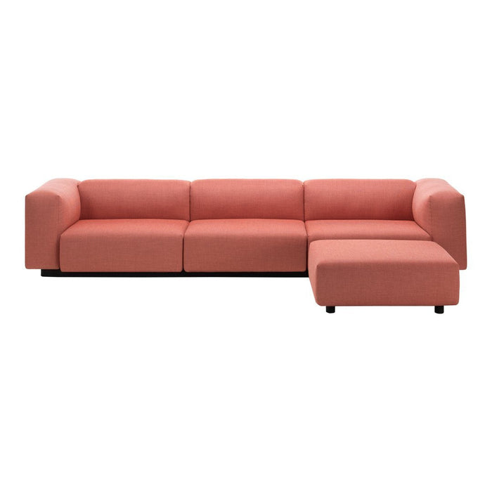 "Modern sectional sofa in soft coral fabric with a minimalist design and plush cushions."