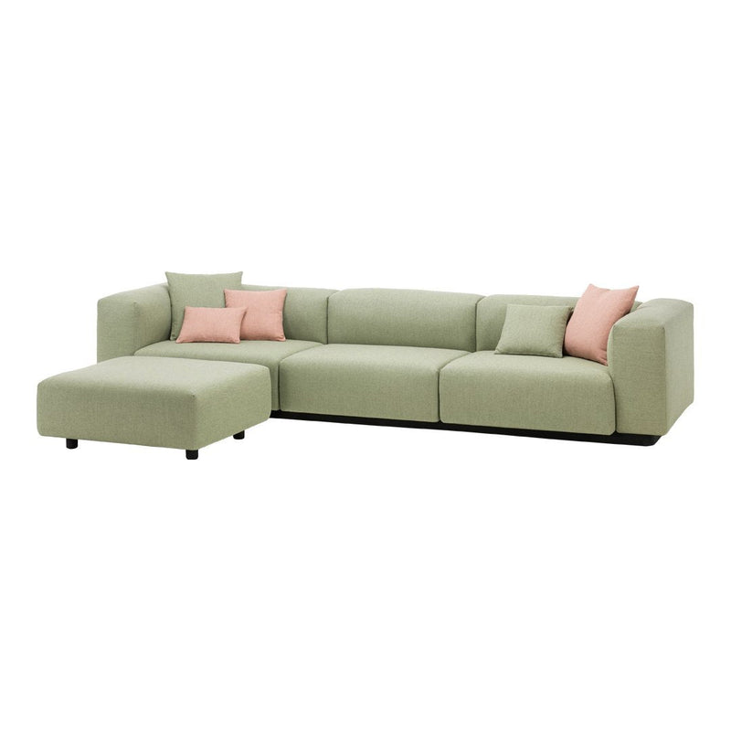 Light green sectional sofa with soft pink accent pillows, featuring a modern, sleek design. Perfect for contemporary living spaces.
