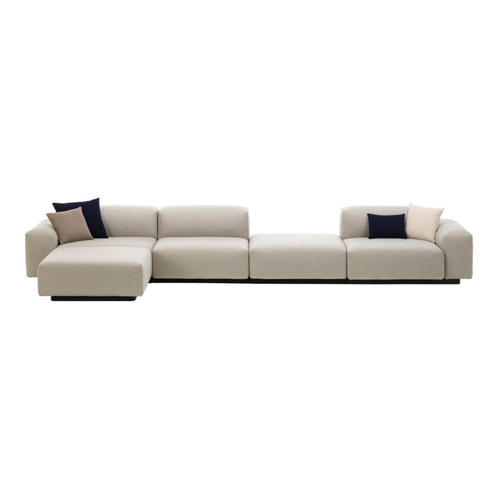 Light beige sectional sofa with navy and blush accent pillows, featuring a sleek, modern design and no patterns.