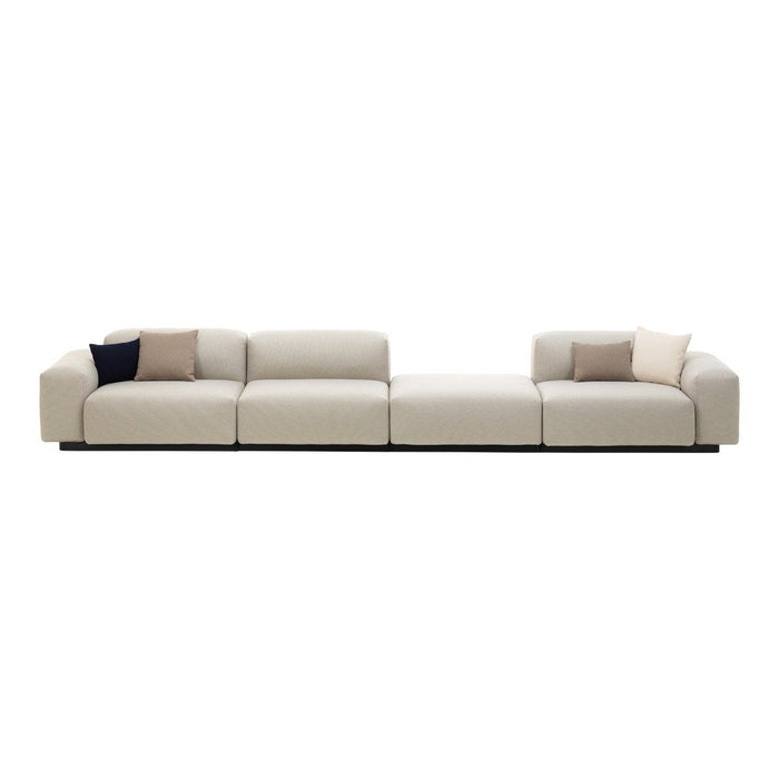 Beige sectional sofa featuring subtle texture and soft accent pillows in muted tones. Modern minimalist design.