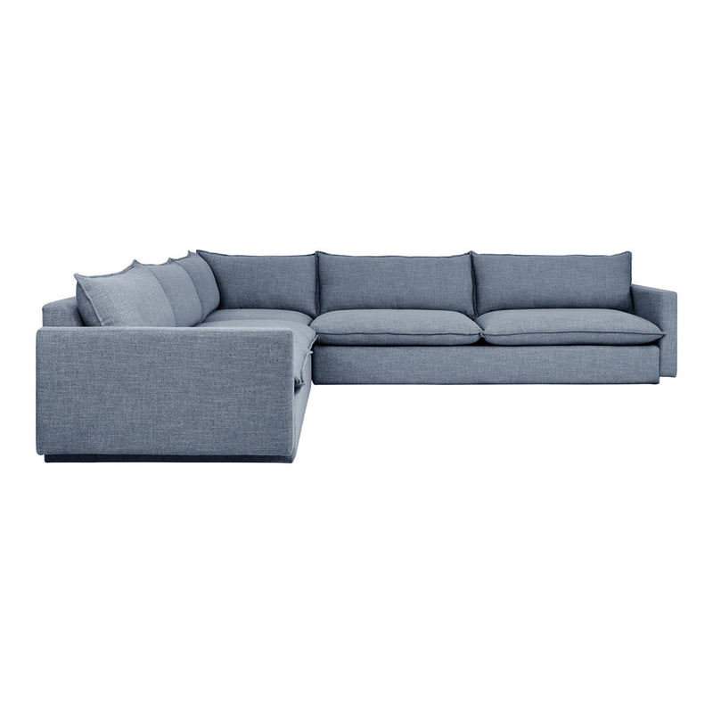 "L-shaped sofa in a soft, textured light blue fabric, featuring solid cushions and a modern minimalist design."