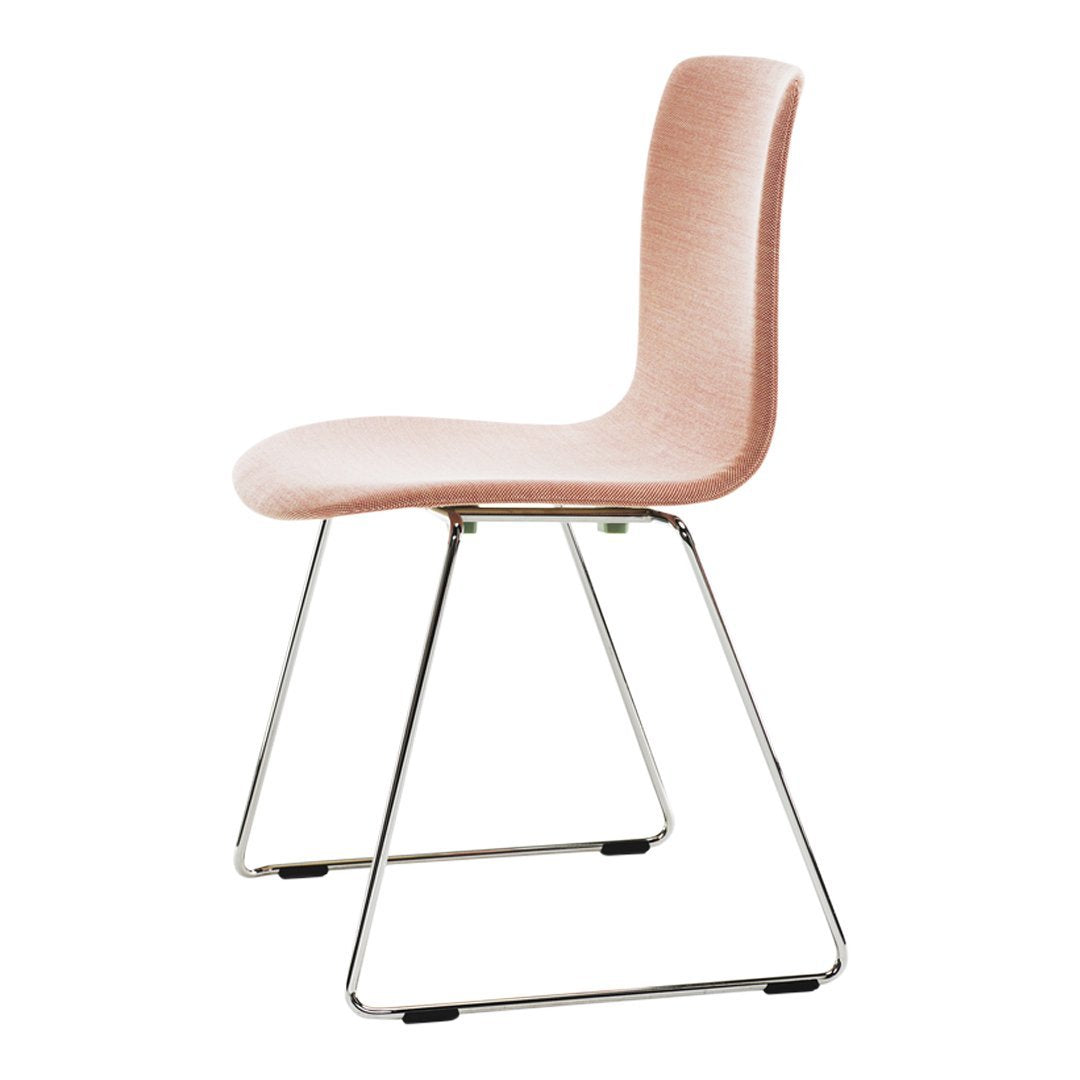 Soft pink upholstered chair with a sleek chrome base, featuring a minimalist design and smooth contours.
