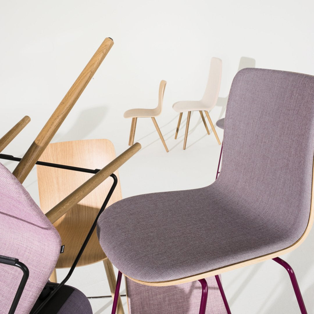 Modern chairs in soft lavender, light beige, and natural wood tones, showcasing sleek, minimalist designs and varied textures.