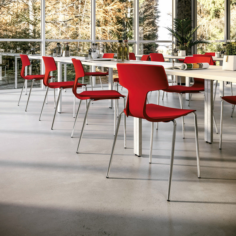 Red chairs with modern design, sleek silver legs, set against a bright and airy dining space.