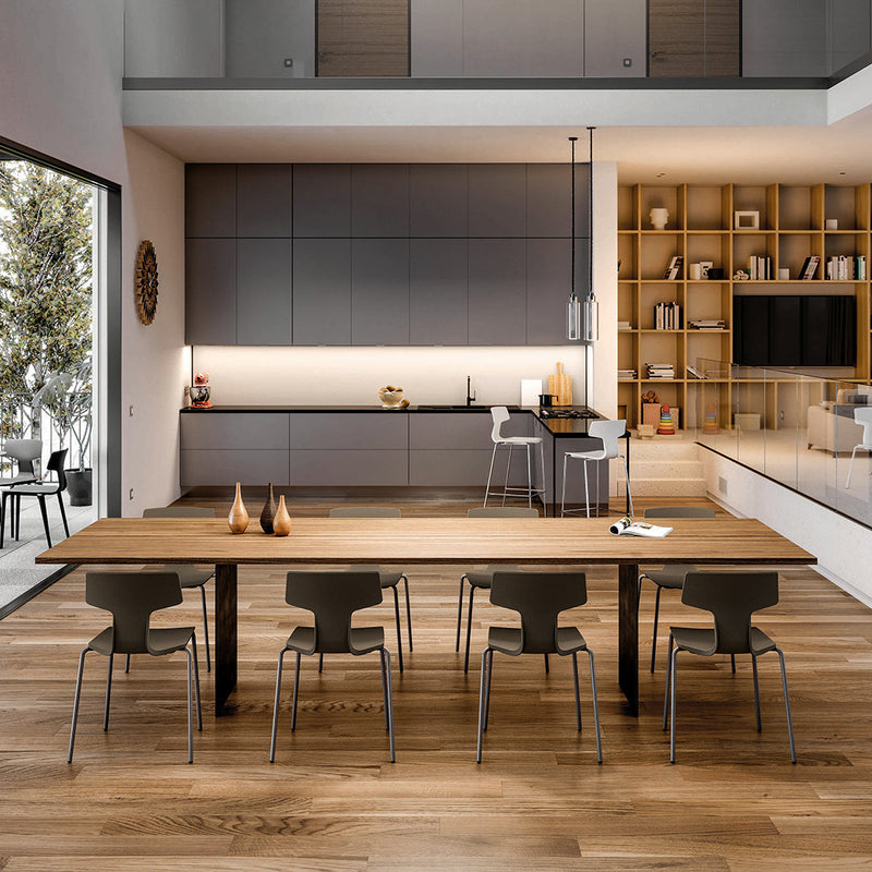 Modern kitchen with a warm wood table, gray cabinetry, and subtle lighting accents, featuring a cozy, minimalist design.