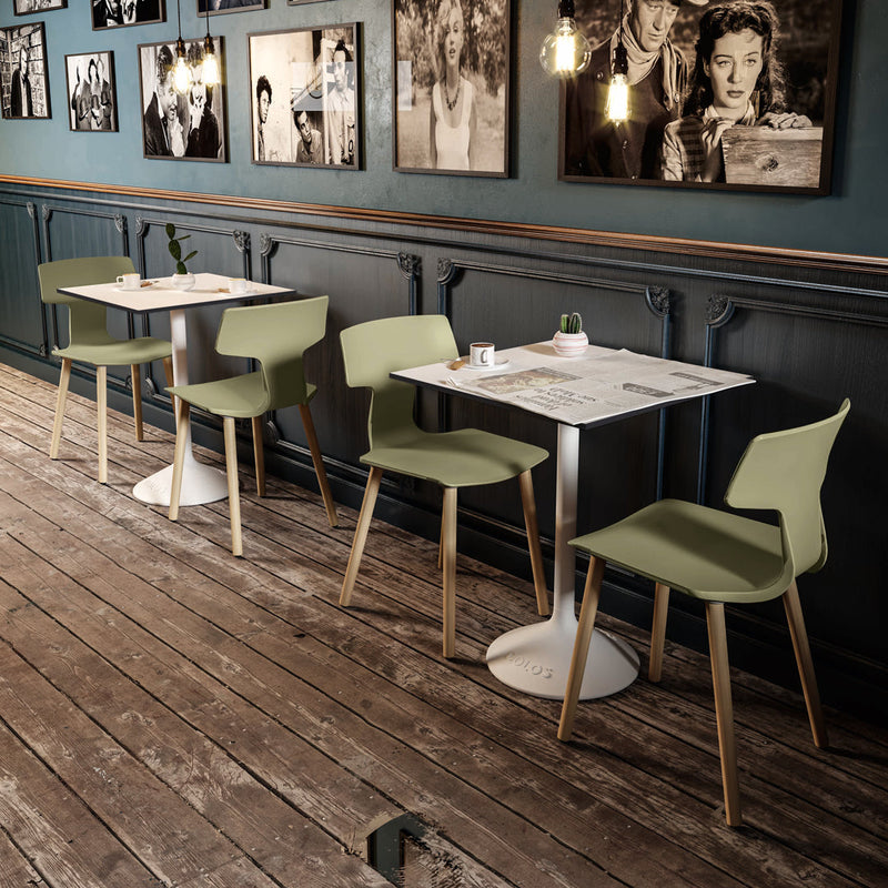 "Modern dining set featuring soft green chairs, white tabletops, and light wood accents against a rustic wooden floor."